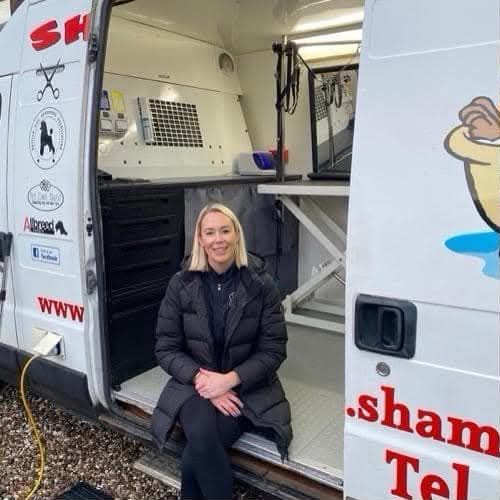 Chantal sitting in the open doorway of the Shampoochies grooming van